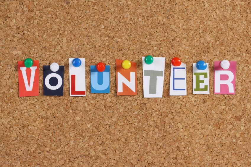 the word "volunteer" with the letters cut out and pinned to a corkboard